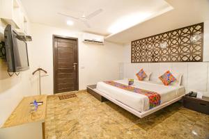 a bedroom with a bed and a flat screen tv at FabHotel White Klove Paharganj in New Delhi