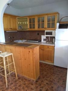 a kitchen with wooden cabinets and a white refrigerator at Szemes Apartman Balaton in Balatonszemes