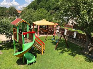 a childrens playground with a slide and an umbrella at Baba Stana Houses in Apriltsi
