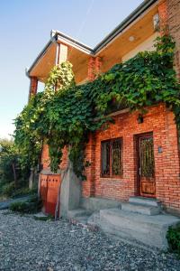 una casa de ladrillo con hiedra creciendo a un lado de ella en Luca Lili, en Signagi