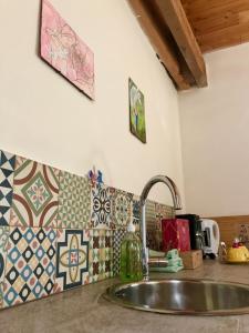 a kitchen counter with a sink and tiles on the wall at Staying with the artist in Teuven