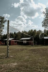a volley ball net in a field with buildings at Atpūtas bāze ODS in Bārta
