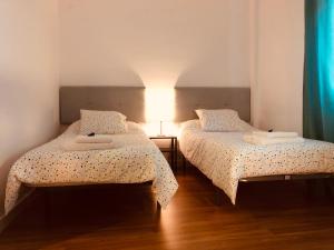 阿奇多納的住宿－LA VICTORIA 1 El Paseo，两张睡床彼此相邻,位于一个房间里