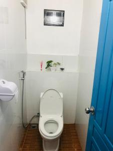 a bathroom with a toilet and a blue door at Naga Hostel & Café in Thakhek