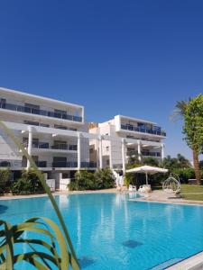 a swimming pool in front of a building at Royal Park- Magical garden apartment in Eilat