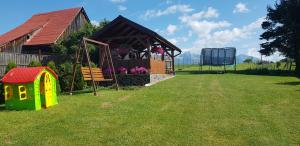 un patio trasero con una casa y un columpio en Apartman Zatura, en Vyšnie Šuňava