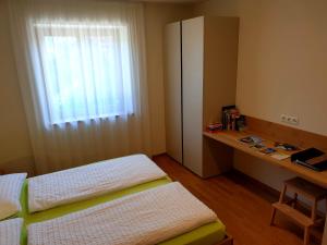 a bedroom with a bed and a dresser and a window at Versigglhof in Appiano sulla Strada del Vino