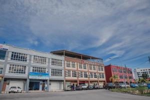 a large building with cars parked in a parking lot at Phoenix Hotel in Gua Musang