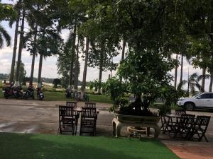 un grupo de sillas y una mesa con un árbol en Hana Riverside Villa, en Quảng Ngãi