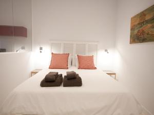 uma grande cama branca com duas toalhas castanhas em Apartamento con encanto en ópera em Madri
