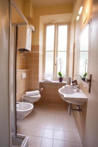 uma casa de banho com 2 lavatórios, um WC e uma janela em Residence Conchiglia Aparthotel em Alassio