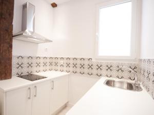 eine weiße Küche mit einem Waschbecken und einem Fenster in der Unterkunft Apartamento con encanto en ópera in Madrid