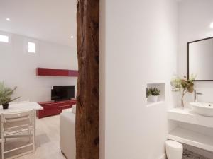 uma casa de banho com paredes brancas, um lavatório e um espelho. em Apartamento con encanto en ópera em Madri