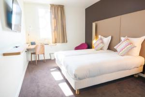 a hotel room with a bed, chair, and nightstand at Hotel Campanile Montpellier Centre St Roch in Montpellier