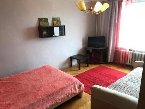 モスクワにあるG-Kvartal Oktyabrskoe Pole Apartmentの赤いベッドと赤い敷物が備わるベッドルーム1室が備わります。