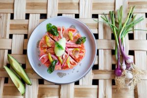 a plate of food with tomatoes and vegetables on a table at Hotel Arima & Spa - Small Luxury Hotels in Donostia-San Sebastián
