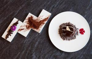 a white plate topped with a piece of chocolate at Hotel Arima & Spa - Small Luxury Hotels in Donostia-San Sebastián