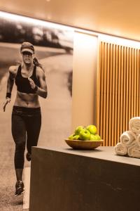 a woman walking past a table with a bowl of fruit at Hotel Arima & Spa - Small Luxury Hotels in Donostia-San Sebastián