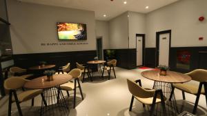 雪邦的住宿－Hotel 99 Sepang KLIA & KLIA2，一间带桌椅的餐厅以及墙上的电视