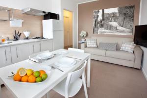a kitchen and living room with a table with a bowl of fruit at AvianResidenze in Aviano