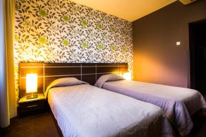 a bedroom with two beds and a wall with flowers at Hemus Hotel - Vratza in Vratsa