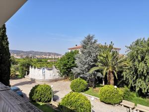 a view of a garden with trees and a building at Hotel ausonia in Corigliano Calabro