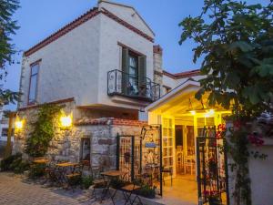 um edifício com mesas e cadeiras em frente em Perla Rossa Alacati em Alacati