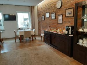a dining room with a table and a brick wall at Preliudija in Klaipėda
