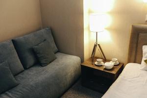 a living room with a couch next to a bed at Vozdvizhenskoe Park Hotel in Serpukhov