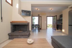 a living room with a fireplace and a couch at Οίνου Γη Ιθάκη - Winelandithaca in Perakhórion