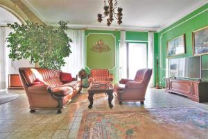 uma sala de estar com duas cadeiras de couro e uma televisão em Seafront captain apartment em Jezera