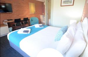 a bedroom with a large white bed with pillows at Bendigo Goldfields Motor Inn in Bendigo