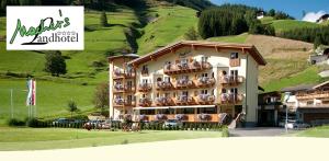 a hotel with a bunch of chairs in front of it at Macher's Landhotel in Sankt Jakob in Defereggen