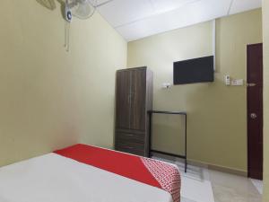 a bedroom with a bed and a tv on the wall at OYO 873 Bamboo Inn in Batu Ferringhi