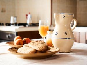a table with a plate of bread and a jug of orange juice at Le Casette di Via Roma in Nardò
