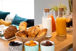 a table with a basket of bread and bottles of milk at Hôtel Eiffel Saint Charles in Paris