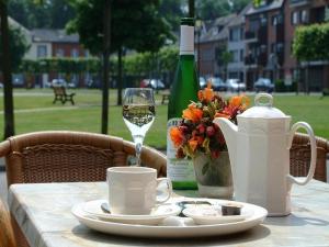 un tavolo con un bicchiere di vino e una bottiglia di vino di Hotel Au Prince Royal a Leopoldsburg