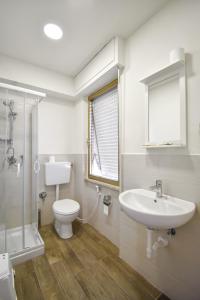 a bathroom with a sink and a toilet and a shower at Hotel La Pineta in Marina di Carrara