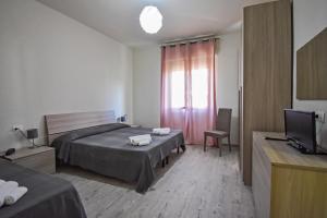 a bedroom with two beds and a television in it at Hotel La Pineta in Marina di Carrara