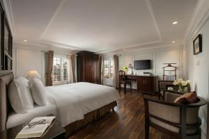 a hotel room with a large bed and a desk at Hong Ngoc Dynastie Boutique Hotel & Spa in Hanoi