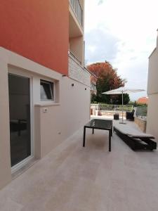a patio of a house with a bench and a table at VILLA POP Apartments Crveni Vrh in Crveni Vrh