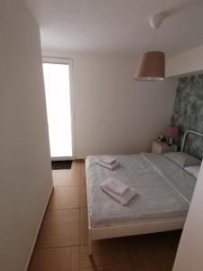 a bedroom with a bed with two towels on it at VILLA POP Apartments Crveni Vrh in Crveni Vrh