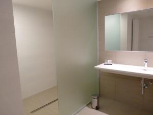 ein Bad mit einem Waschbecken und einem Spiegel in der Unterkunft Hotel Au Prince Royal in Leopoldsburg
