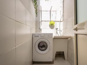 Un baño con lavadora y lavabo. en Appartamento L'arcobaleno, en Cagliari