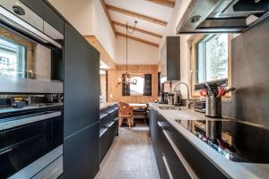 cocina con electrodomésticos de acero inoxidable y mesa en Chalet Steinbock by Arosa Holiday en Arosa