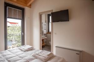 a bedroom with a bed with a flat screen tv on the wall at foresteria stazzona in Villa di Tirano