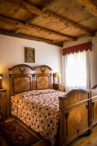 a bedroom with a large wooden bed in a room at B&B Gastaldo di Rolle in Cison di Valmarino
