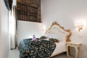- une chambre dotée d'un lit blanc avec un cadre doré dans l'établissement Al Mascaron Ridente, à Venise
