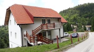a small white house with an orange roof at Apartments Panovic in Kopaonik