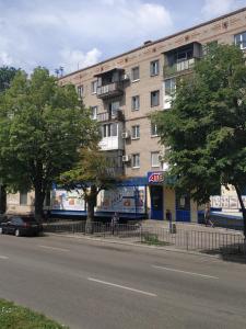 a building on the side of a street with trees at Apartment at Kirova (A.Polia) in Dnipro